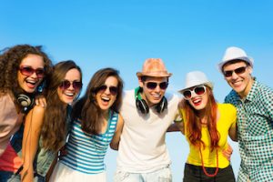 group of young adult friends huddled together and wearing sunglasses