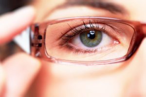 woman holding glasses up to her eye